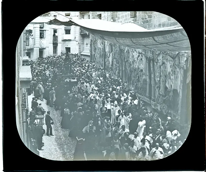 La Custodia de Arfe bajo los toldos descendiendo por la calle Arco de Palacio adornada con tapices en los muros de la catedral. Años 20. Fondo Rodríguez. AHP Toledo.