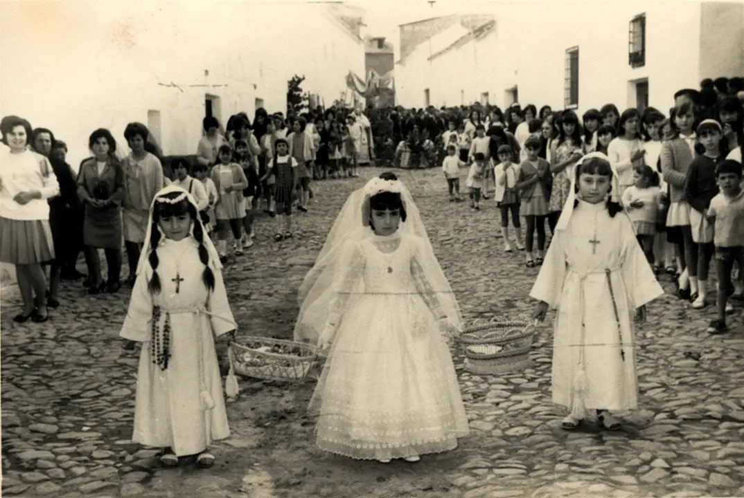 Niñas de Primera Comunión preceden el paso de la Custodia en la procesión del Corpus Christi de Alhambra (Ciudad Real). Años 60. Fondo Los Legados de la Tierra. Archivo de la Imagen de Castilla-La Mancha.