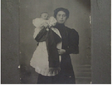J. Alcaide con lazo de luto en brazos de su madre