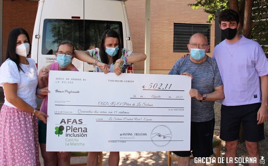 Antonio Naranjo, Nuria Cabello y residentes del CADIG El Pilar con el cheque