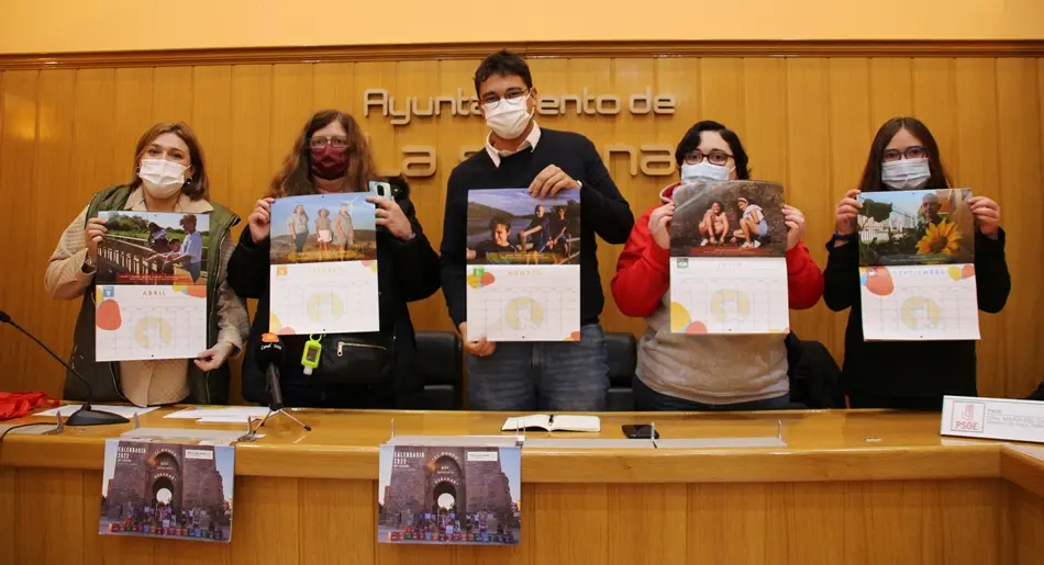 Componentes de Afanion y el alcalde posan con sus calendarios en el salón de plenos
Foto: GACETA
