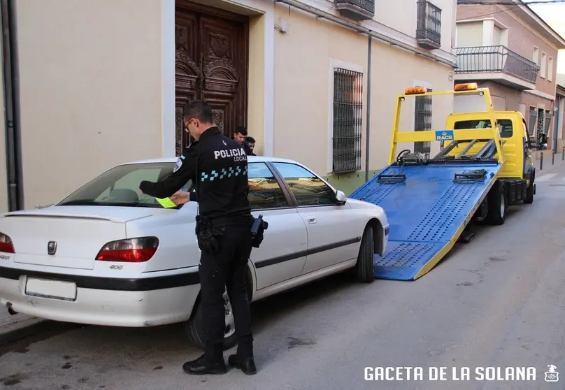 Grúa retira un coche el Jueves Santo en la calle Carrera de La Solana