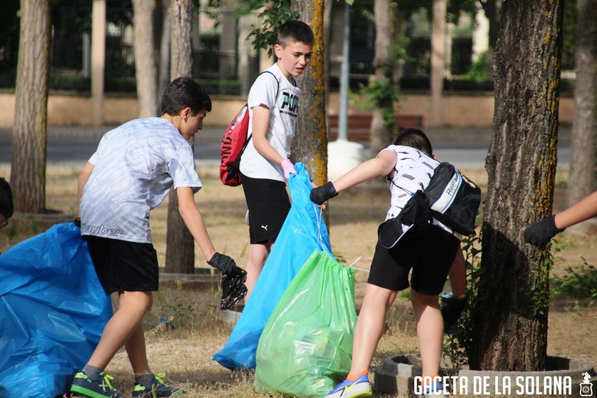 Varios jóvenes recogiendo basura en la Avenida del Deporte de La Solana