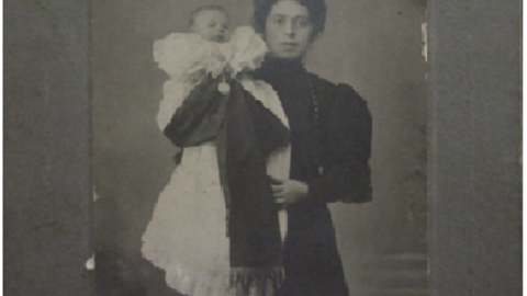 J. Alcaide con lazo de luto en brazos de su madre