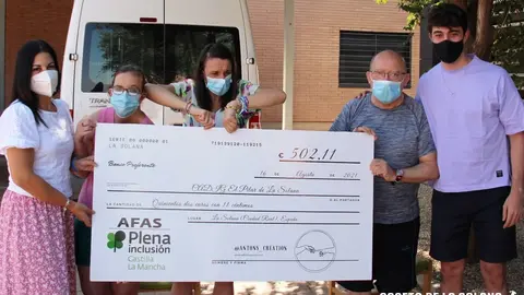 Antonio Naranjo, Nuria Cabello y residentes del CADIG El Pilar con el cheque