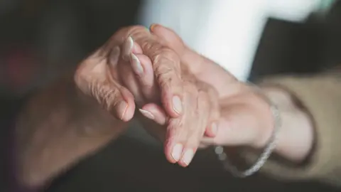 Una persona da la mano a una señora enferma de alzheimer
Foto: RTVE