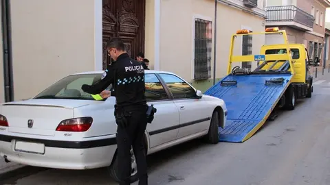 Grúa retira un coche el Jueves Santo en la calle Carrera de La Solana