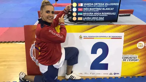 Vanessa Ortega Villodres posando junto a la pantalla en la que aparece en la 1ª posición del Campeonato de España