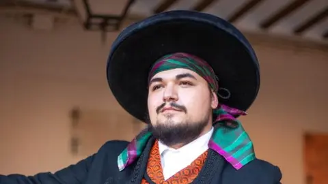 Javier Ramírez vestido con indumentarias manchegas y sombrero de ala ancha, Belén Mora