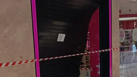 Entrada de la perfumería destrozada