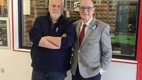 Juli&aacute;n Camacho, junto a Julio Criado, luciendo el lazo azul celeste realizado a ganchillo por Adela Jim&eacute;nez