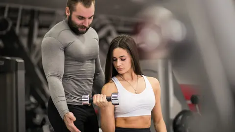 Woman at gym with coach