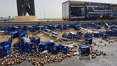 Cientos de botellines de cerveza quedan esparcidos en la rotonda de la 'Ñ' tras salirse de un camión